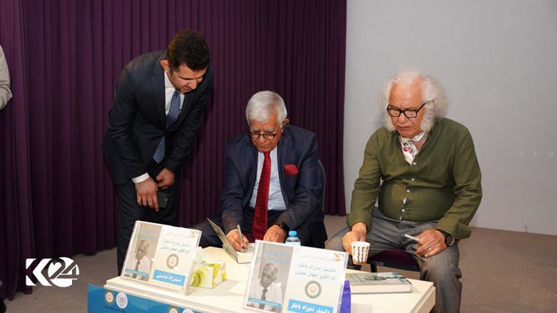 Nawzad Bajgr signs his memoir during the book launch ceremony in Erbil, June 1, 2022. (Photo: Cihan University Website)